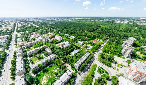 Vista aérea de la ciudad con encrucijadas y caminos, casas, edificios, parques y estacionamientos. Imagen panorámica soleada de verano — Foto de Stock