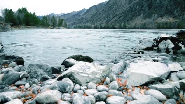 Dolly deslizador de tiro de las salpicaduras de agua en un río de montaña cerca del bosque. Rocas húmedas y rayos de sol. Movimiento horizontal constante. — Vídeo de stock