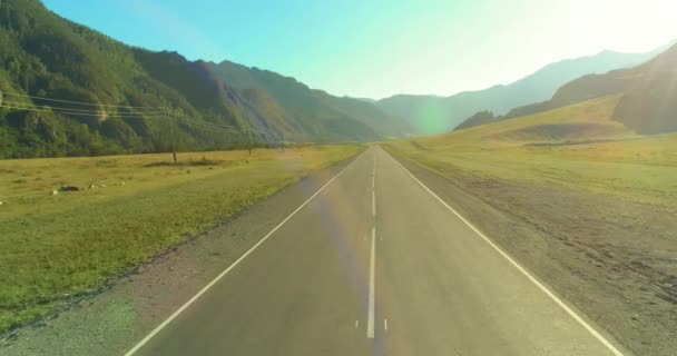 Повітряні низькі повітряні польоти над гірською дорогою і лугом в сонячний літній ранок . — стокове відео