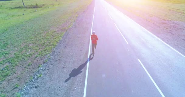 Lavhøydeflyging foran sportsmann på perfekt asfaltvei – stockvideo