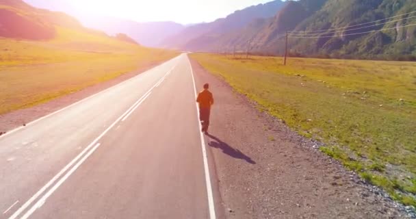 Tiefflug vor sportlichem Mann auf perfekter Asphaltstraße — Stockvideo