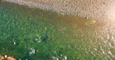 Güneşli yaz sabahında kayalarla birlikte taze, hızlı dağ nehri üzerinde alçak irtifa uçuşu..