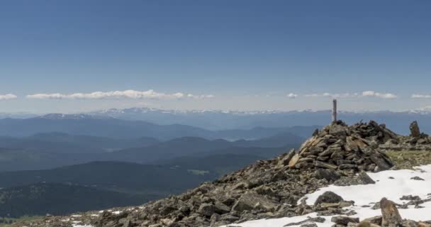 Tidsförskjutning av molnlandskap bakom bergstoppen. Snö, stenar, klippor och djupblå himmel. Hög höjd. — Stockvideo