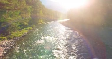 Güneşli yaz sabahında kayalarla birlikte taze, hızlı dağ nehri üzerinde alçak irtifa uçuşu..