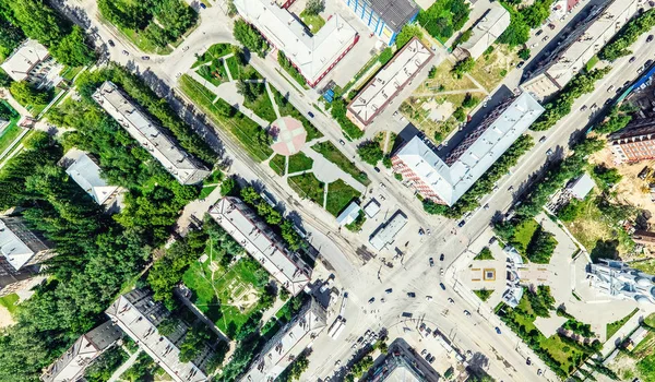 Vista aérea da cidade com encruzilhada e estradas, casas, edifícios, parques e estacionamentos. Verão ensolarado imagem panorâmica — Fotografia de Stock