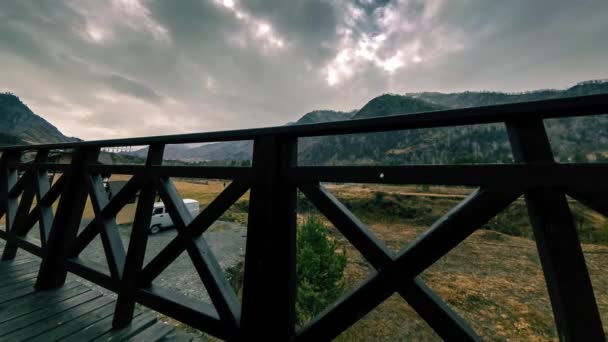 Timelapse van houten hek op hoog terras bij berglandschap met wolken. Horizontale schuifbeweging — Stockvideo