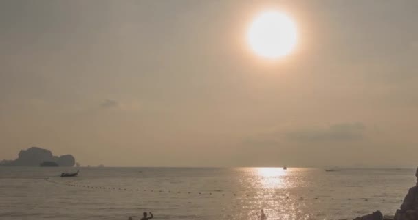 Napnyugtakor fénysugarak csapnak le a tengerre vagy az óceánra. Meleg nyári időjárás a trópusokon. Panoráma mozgás. — Stock videók