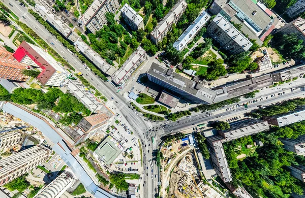 Vista aérea de la ciudad con encrucijadas y caminos, casas, edificios, parques y estacionamientos. Imagen panorámica soleada de verano — Foto de Stock