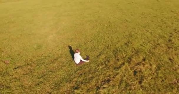 黄色の田園地帯でノートパッドと緑の芝生の上の人間の周りの低軌道飛行. — ストック動画