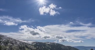 Dağların arkasındaki bulutların zaman çizelgesi. Kar, kayalar, uçurumlar ve derin mavi gökyüzü. Yüksek irtifa.