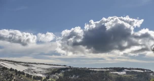 Time lapse de paysage nuageux derrière le sommet des montagnes. Neige, rochers, falaises et ciel bleu profond. Haute altitude.
