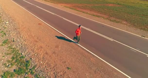 Vuelo de baja altitud frente al deportista en el camino perfecto de asfalto — Vídeo de stock