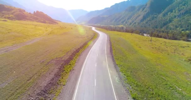 Terbang di atas gunung aspal jalan raya dan padang rumput — Stok Video