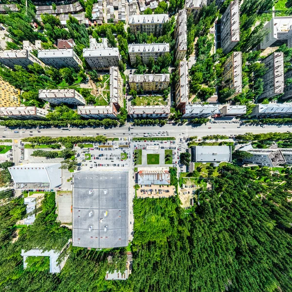 Vista aérea de la ciudad con encrucijadas y caminos, casas, edificios, parques y estacionamientos. Imagen panorámica soleada de verano — Foto de Stock