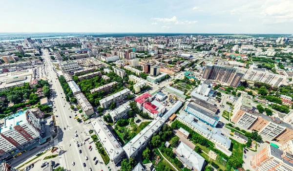 Vista aérea de la ciudad con encrucijadas y caminos, casas, edificios, parques y estacionamientos. Imagen panorámica soleada de verano —  Fotos de Stock