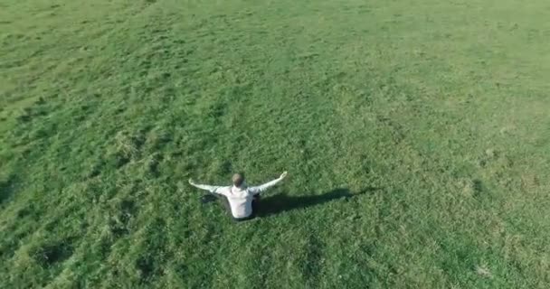 黄色の田園地帯でノートパッドと緑の芝生の上の人間の周りの低軌道飛行. — ストック動画
