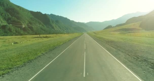 夏日阳光明媚的早晨，空中低空飞越山路和草地. — 图库视频影像