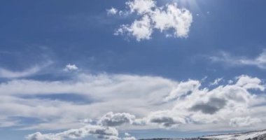 Dağların arkasındaki bulutların zaman çizelgesi. Kar, kayalar, uçurumlar ve derin mavi gökyüzü. Yüksek irtifa.