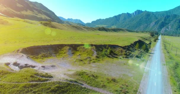 Aerea strada di montagna rurale e prato al sole mattina d'estate. Autostrada asfaltata e fiume. — Video Stock