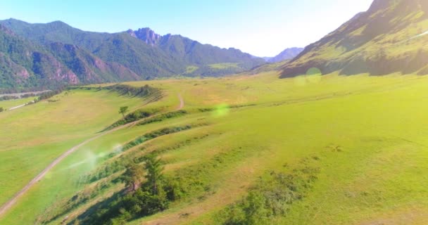 Luchtfoto landelijke bergweg en weide op zonnige zomerochtend. Asfaltweg en rivier. — Stockvideo