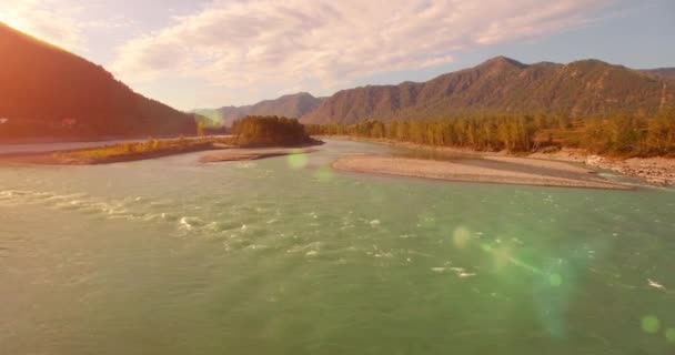 4k UHD vanuit de lucht gezien. Lage vlucht over frisse koude bergrivier op zonnige zomerochtend. Groene bomen en zonnestralen op horisont — Stockvideo