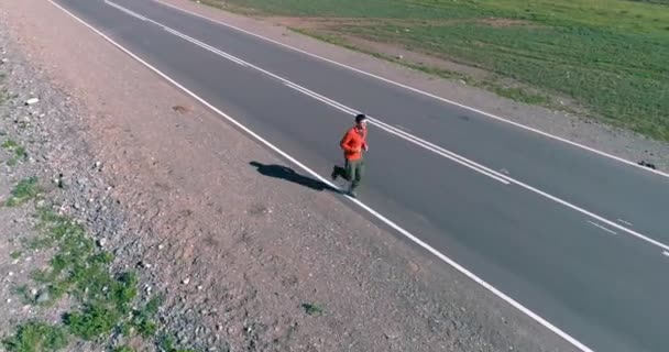 Vol à basse altitude devant un sportif sur une route asphaltée parfaite — Video