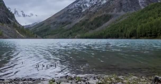 Timelapse lago de montaña en la hora de verano u otoño. Naturaleza salvaje y valle montañoso rural. Bosque verde de pinos y nubes rápidas en el cielo. Movimiento deslizante de dolly motorizado — Vídeo de stock