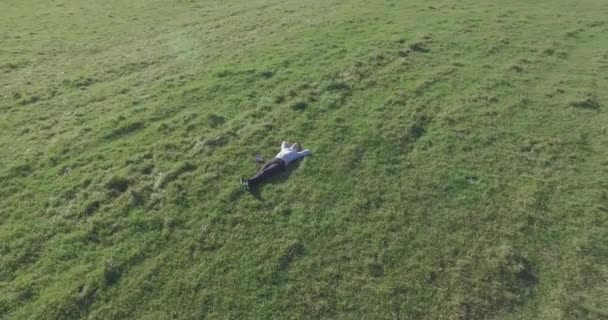 黄色の田園地帯でノートパッドと緑の芝生の上の人間の周りの低軌道飛行. — ストック動画