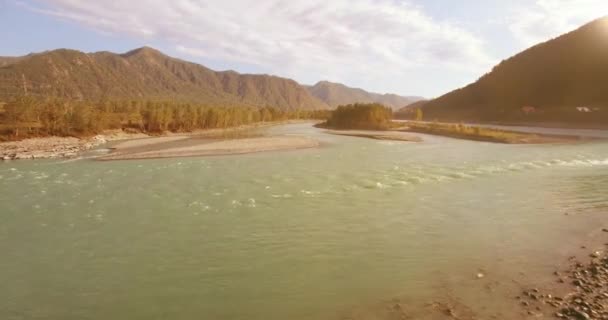 Низкая высота полета над свежей быстрой горной рекой с камнями в солнечное летнее утро. — стоковое видео