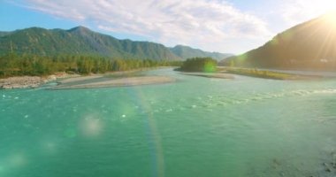Güneşli yaz sabahında kayalarla birlikte taze, hızlı dağ nehri üzerinde alçak irtifa uçuşu..