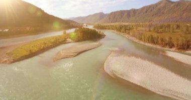 Güneşli yaz sabahında kayalarla birlikte taze, hızlı dağ nehri üzerinde alçak irtifa uçuşu..