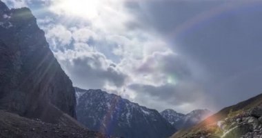 Yaz ya da sonbahar zamanı dağ vadisindeki destansı bulutların zamanı. Vahşi sonsuz doğa ve kar fırtınası gökyüzü. Kar zirvesinde güneş ışınları