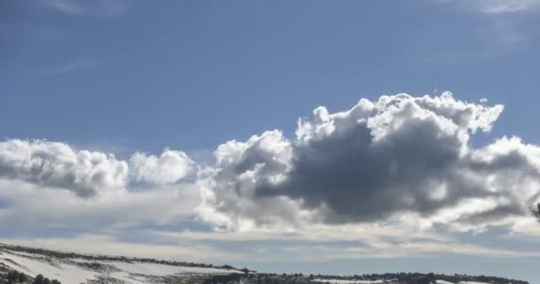 Tijdsverloop van het wolkenlandschap achter de bergtop. Sneeuw, rotsen, kliffen en een diepblauwe lucht. Hoge hoogte. — Stockvideo