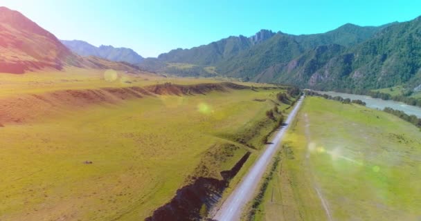 Letecká horská cesta a louka za slunečného letního rána. Asfaltová dálnice a řeka. — Stock video
