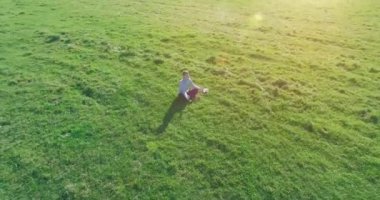 Yeşil çimlerin üzerinde sarı kırsal alanda not defteri olan bir adamın etrafında alçak yörünge uçuşları..