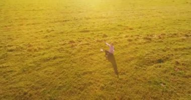 Yeşil çimlerin üzerinde sarı kırsal alanda not defteri olan bir adamın etrafında alçak yörünge uçuşları..