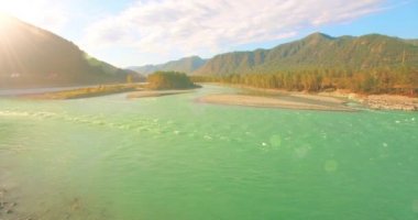 Güneşli yaz sabahında kayalarla birlikte taze, hızlı dağ nehri üzerinde alçak irtifa uçuşu..