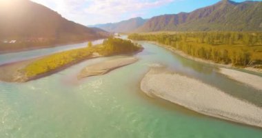 Güneşli yaz sabahında kayalarla birlikte taze, hızlı dağ nehri üzerinde alçak irtifa uçuşu..