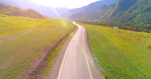 Dağda asfalt karayolu ve çayır üzerinde uçuş — Stok video