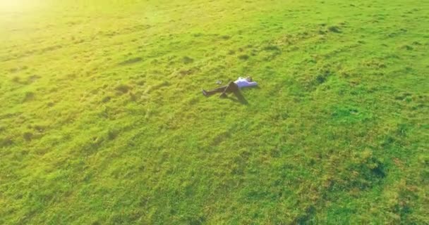 노란색 시골 들판에 노트북 패드가 있는 푸른 잔디 위에서 사람 주위를 낮은 궤도 비행. — 비디오