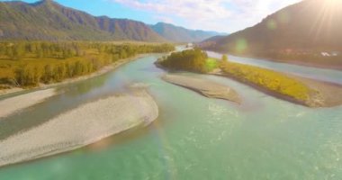 Güneşli yaz sabahında kayalarla birlikte taze, hızlı dağ nehri üzerinde alçak irtifa uçuşu..