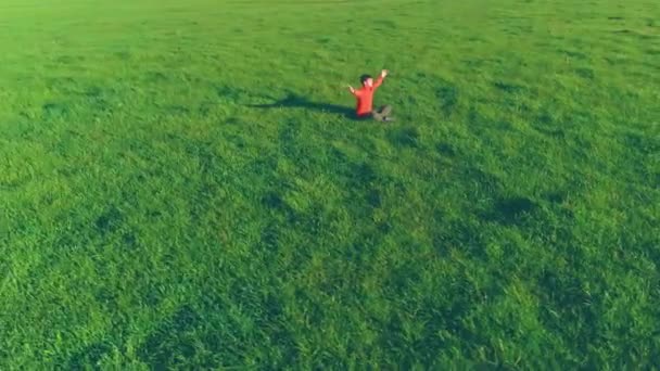 Lage hoogte radiale vlucht over sport yoga man op perfect groen gras. Zonsondergang in de bergen. — Stockvideo