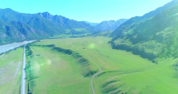 Camino de montaña rural aéreo y prado en la soleada mañana de verano. Autopista del asfalto y río. — Vídeos de Stock