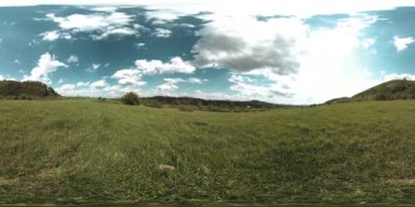 360 VR 'lık güzel bir dağ çayırı zaman dilimi. Yaz ya da sonbahar zamanında. Bulutlar, yeşil çimenler ve güneş ışınları.