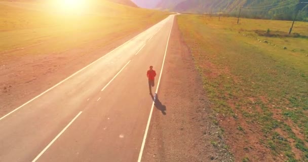 Volo a bassa quota di fronte all'uomo sportivo in perfetta strada asfaltata — Video Stock