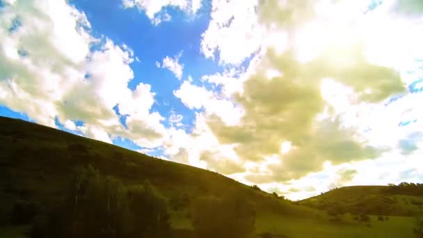 4K UHD mountain meadow timelapse at the summer. Clouds, trees, green grass and sun rays movement. — Stock Video