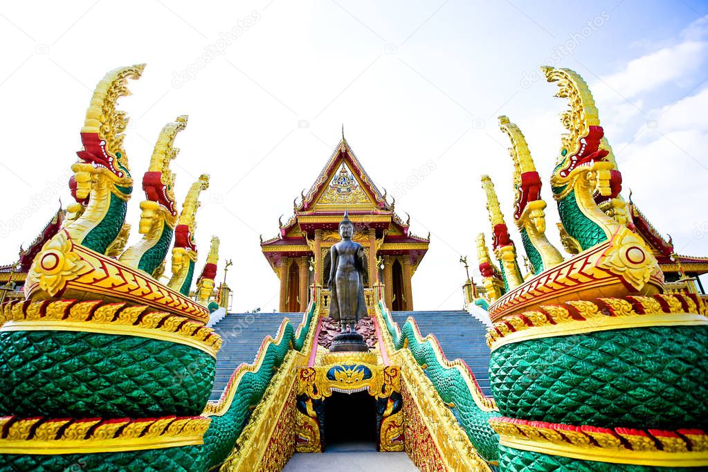 Naga statue infront of Thai style golden castle, Thailand.