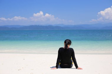 Deniz kenarında oturan kadın