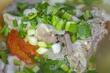 Baharatlı domuz kemiği çorbası, ana yemekle yenir.