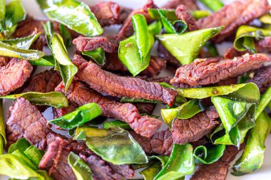 Kızarmış geyik eti, sarımsak ve Tayland bitkisi.